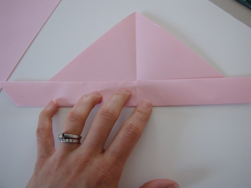 Fold up the long edge of the triangle.