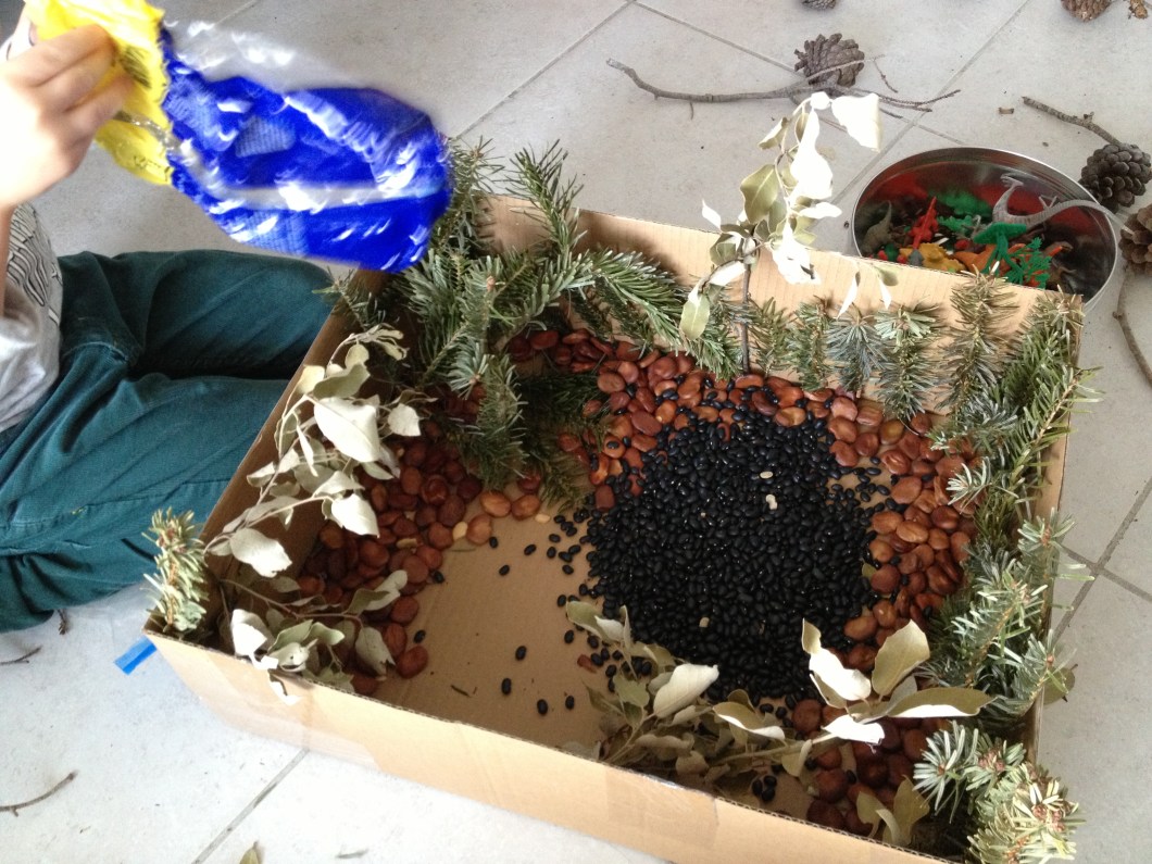 Hot glue twigs, leaves, etc. Add beans- lighter colors allow for the dinosaurs to be seen more clearly.