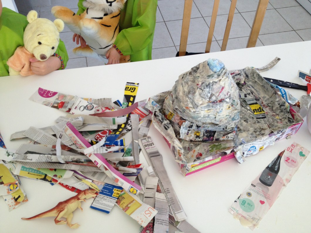 Once you have the volcano shape that you want, dip strips of paper into your homemade glue and over up your volcano and its surrounding area.