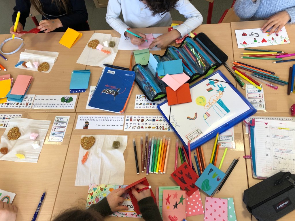 ESL conversation questions for Valentine's Day are used to make cards for classmates. This photo shows some cards with personal messages and decorations.