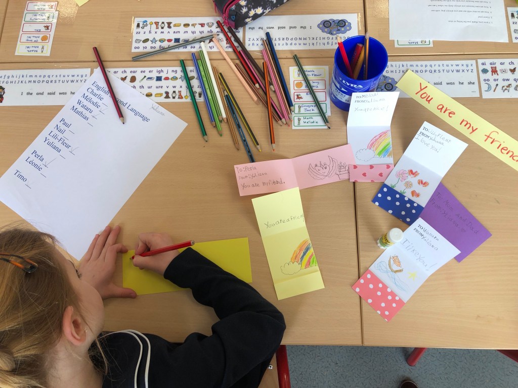 ESL conversation questions for Valentine's Day are used to make cards for classmates. This photo shows some cards with personal messages and decorations.