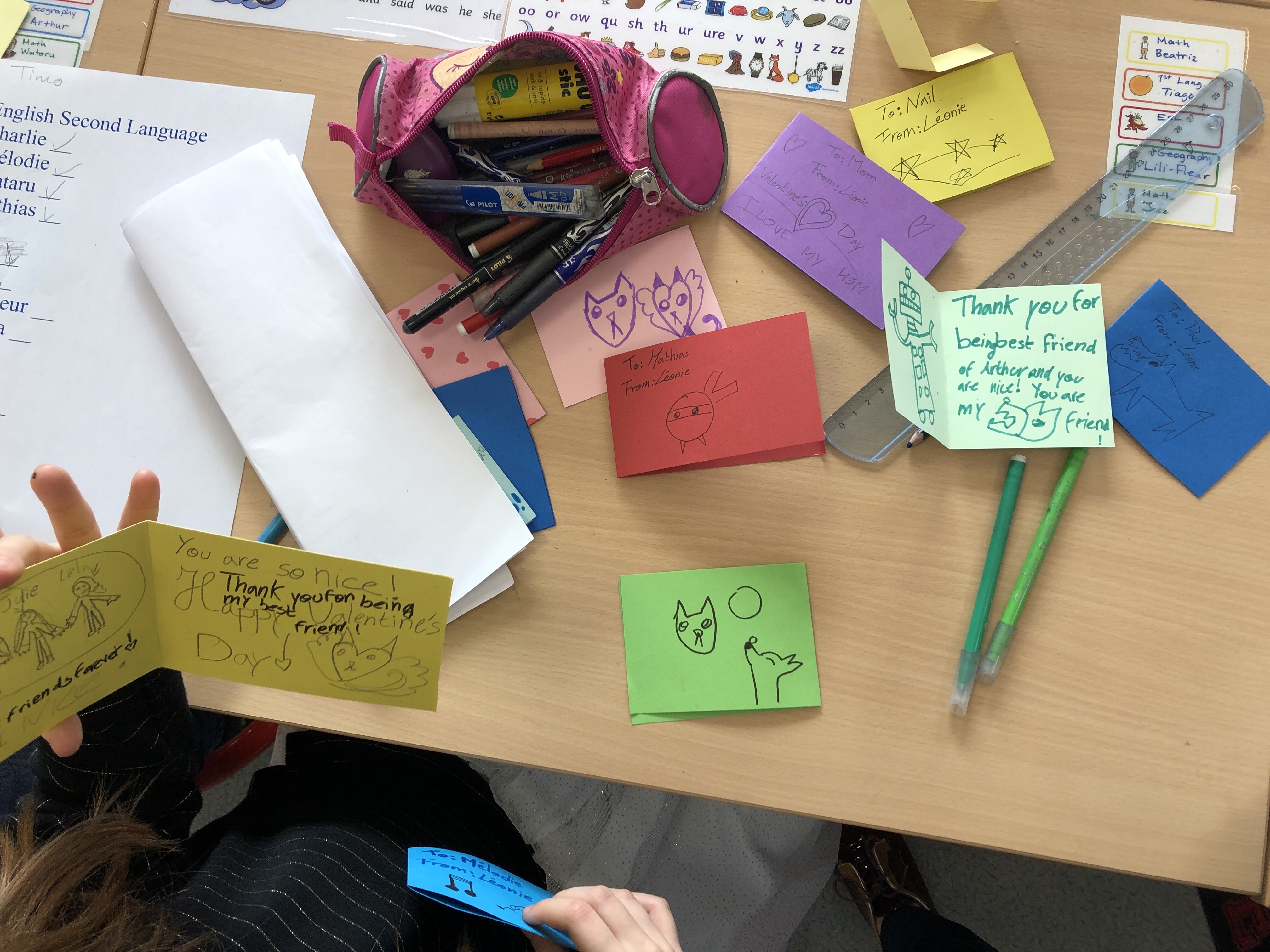 ESL conversation questions for Valentine's Day are used to make cards for classmates. This photo shows some cards with personal messages and decorations.