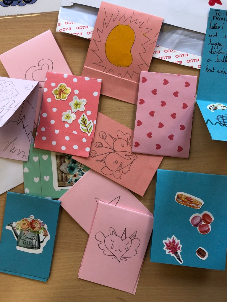 ESL conversation questions for Valentine's Day are used to make cards for classmates. This photo shows some cards with personal messages and decorations.